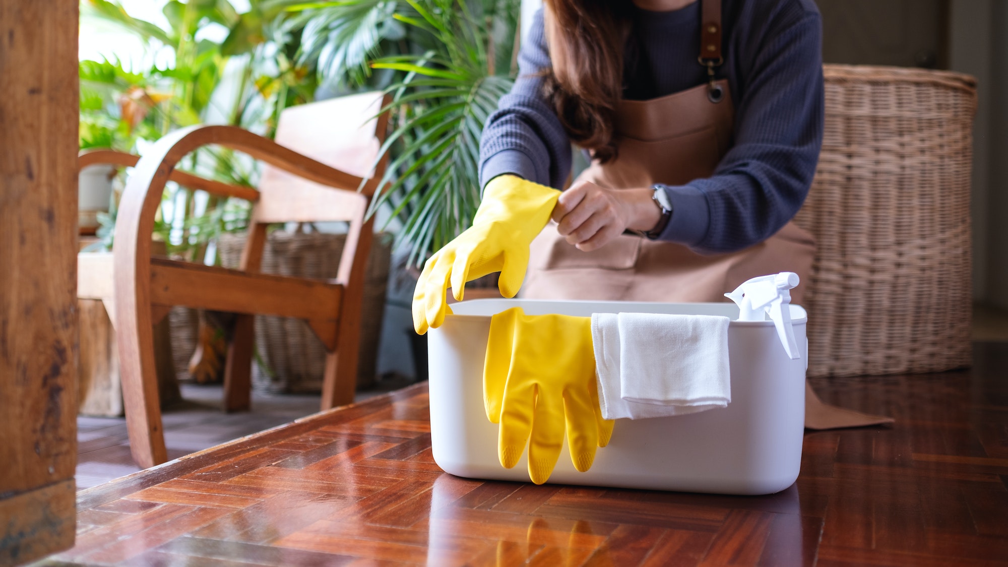 A young woman put on protective gloves before cleaning house