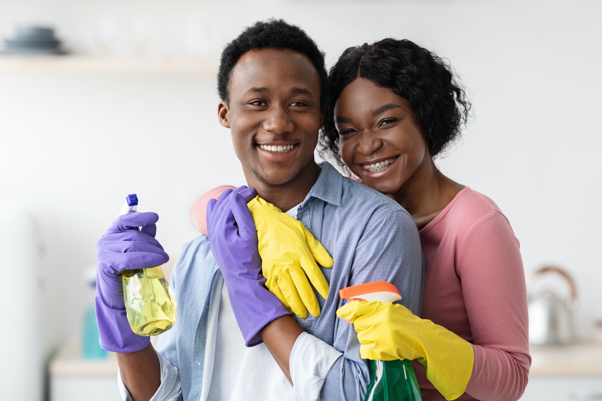 Happy black lovers embracing while cleaning house